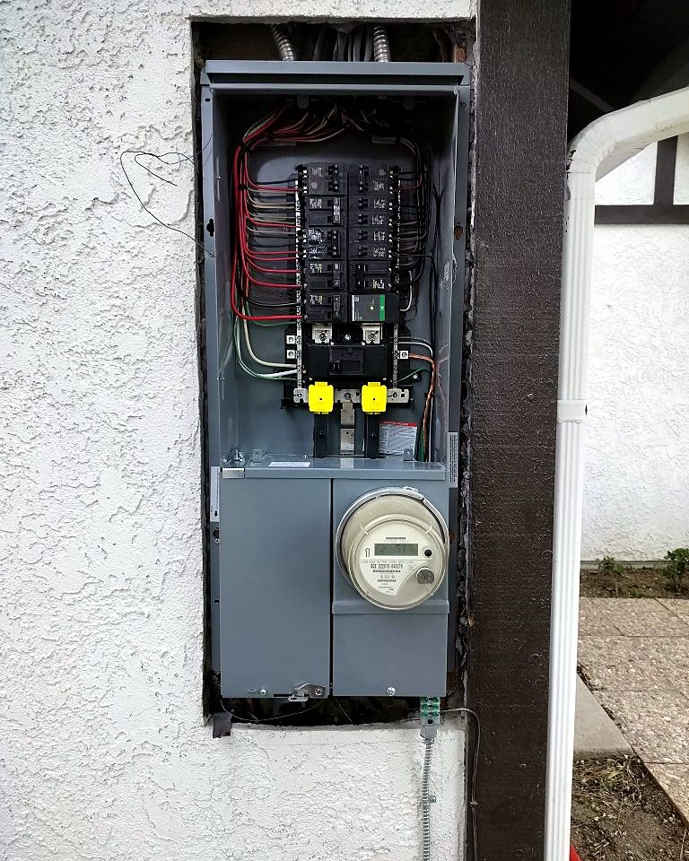 Replacement panel and meter set into a stucco exterior wall