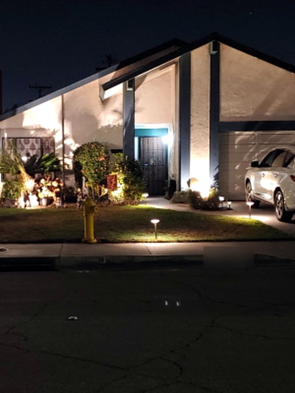 Front yard landscape lighting with path lights and accent lights illuminating a home at night