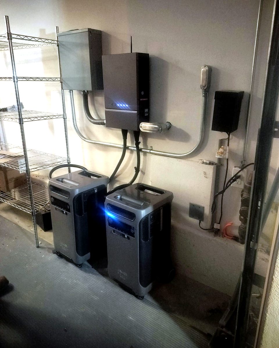 Home battery backup system with wall-mounted equipment and two battery units in a garage