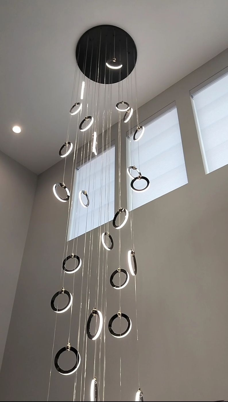 Spiral LED ring chandelier installed in a two-story home foyer