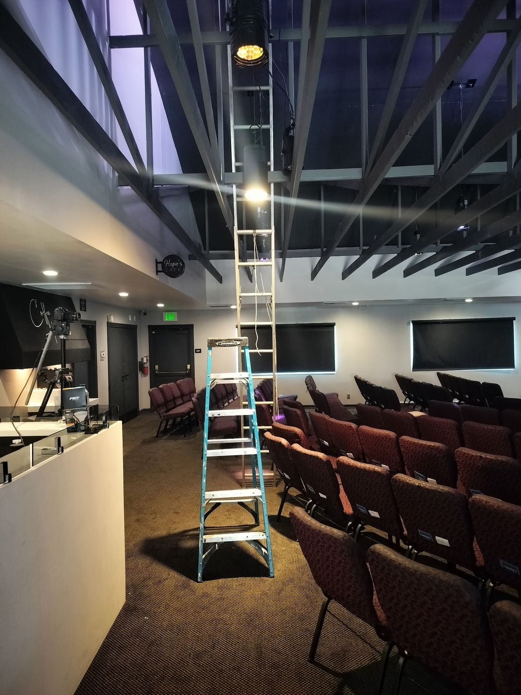 Stage lighting fixture mounted on a ceiling truss in a church auditorium